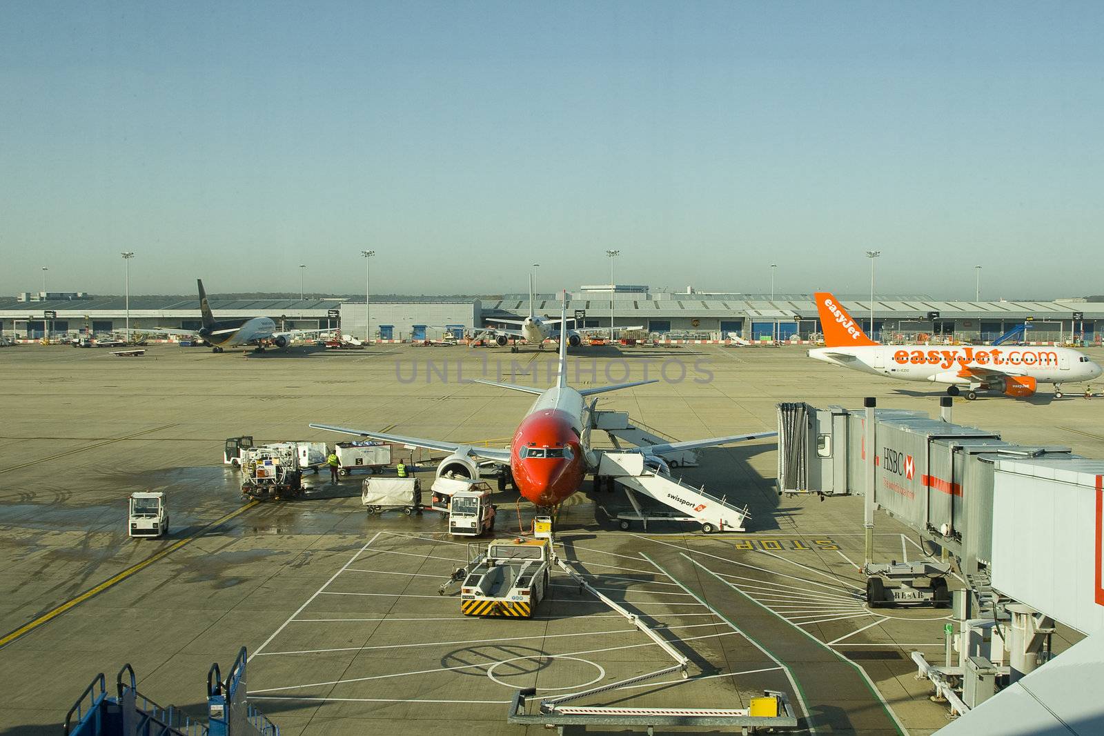 A Norwegian Air Shuttle airplane gets maintenance and refueling before accepting new passengers at London Stansted Airport. Easyjet is in the background, off to departure.