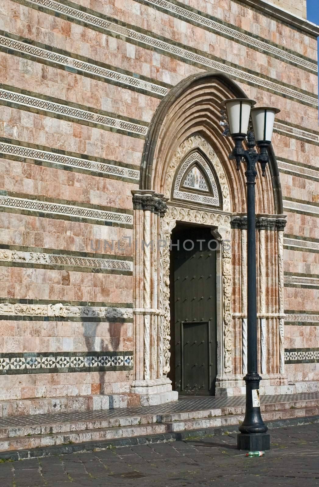 Italian cathedral's portal with streetlamp