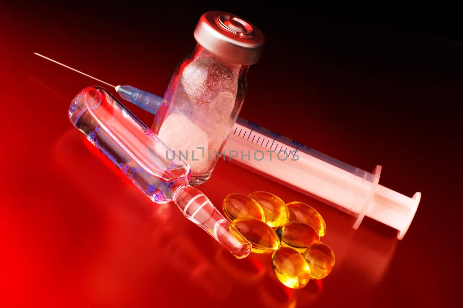 Syringe with medicine bottles and pills with dramatic light