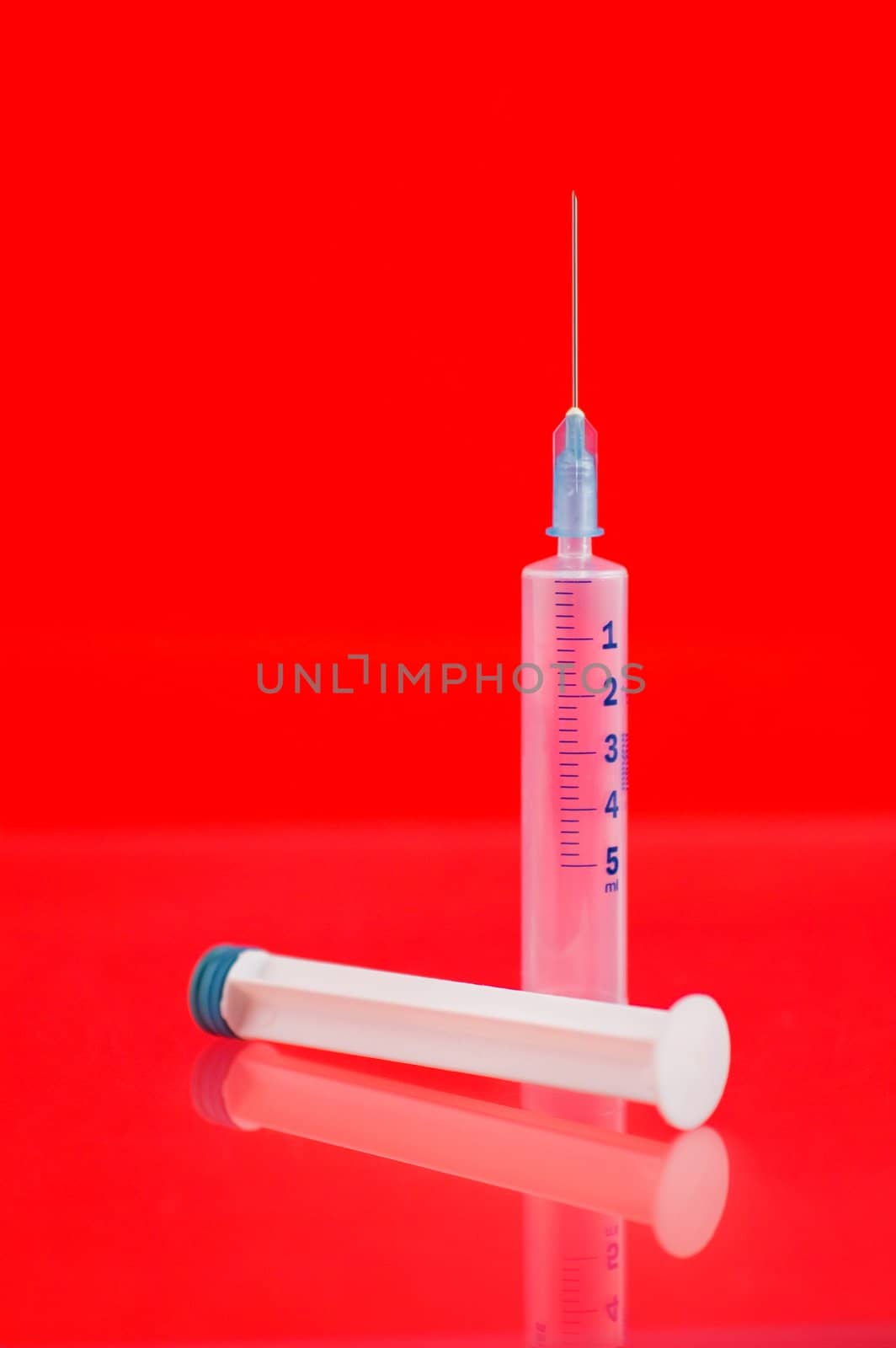 Syringe on red background