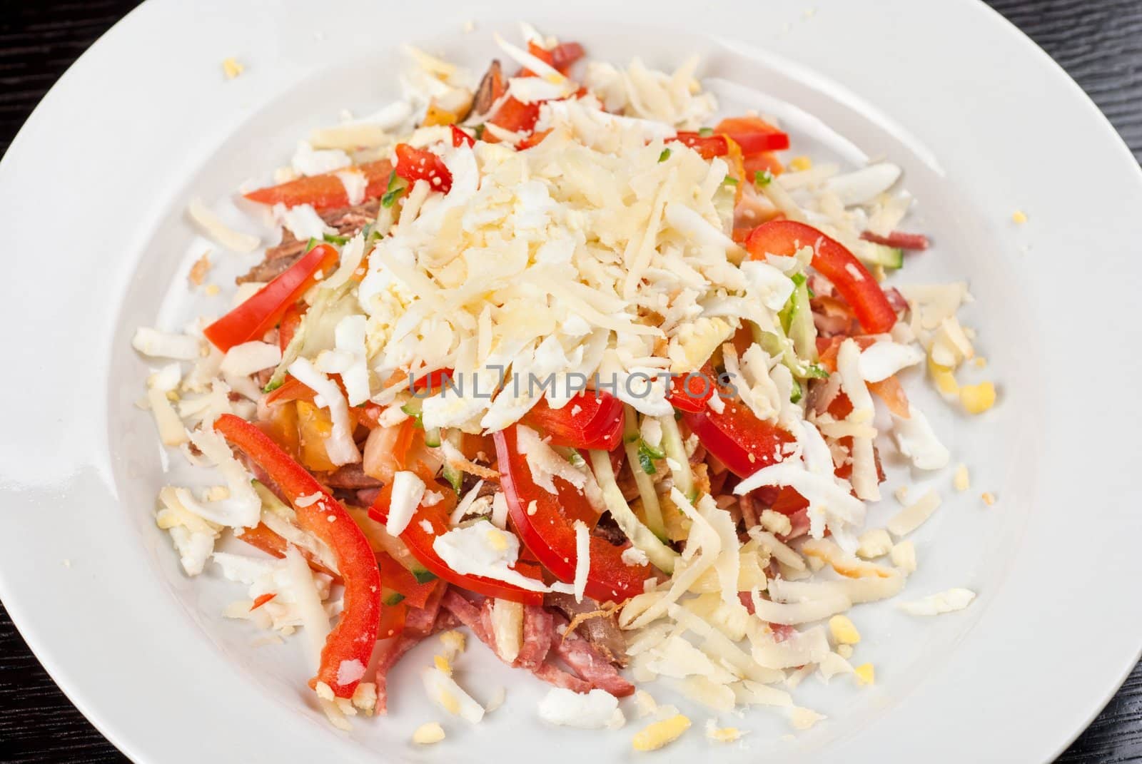 Salad from beef tongue, cervelat, chicken meat, fresh tomatoes, cucumbers, pepper, eggs, cheese and mayonnaise