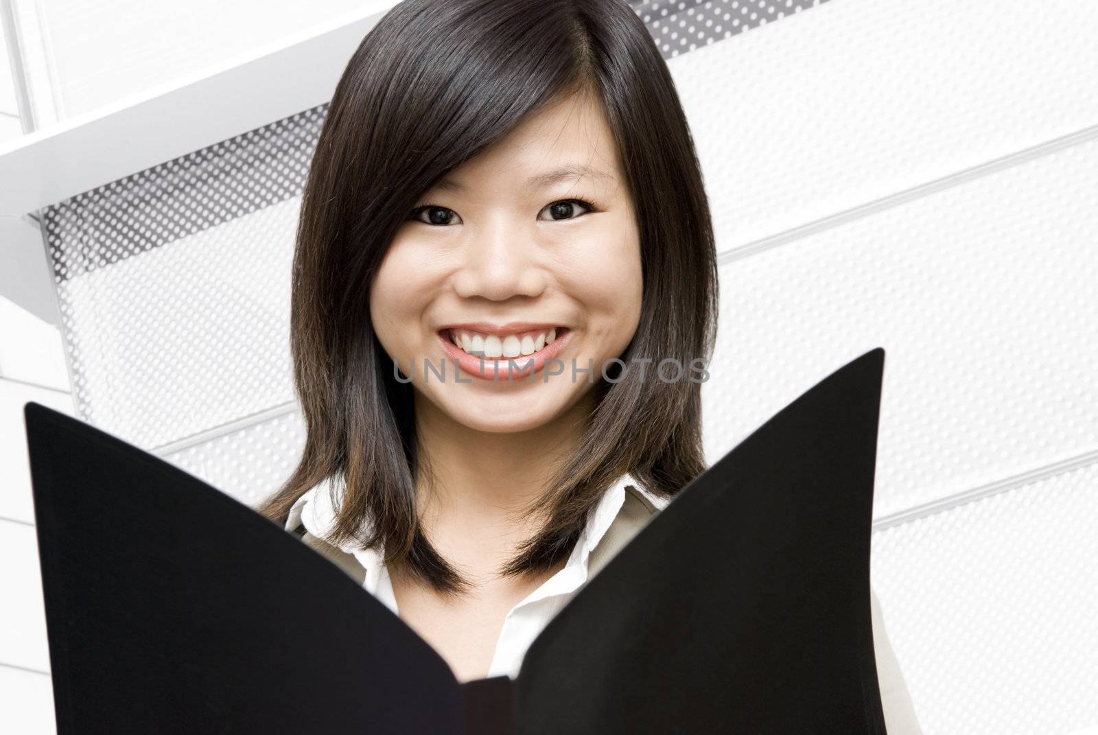 Young Asian women holding a file in office environment 
