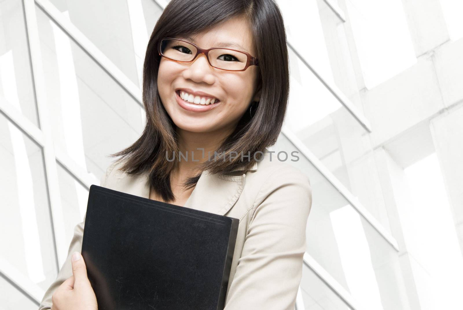 Young Asian women holding a file in office environment. 
