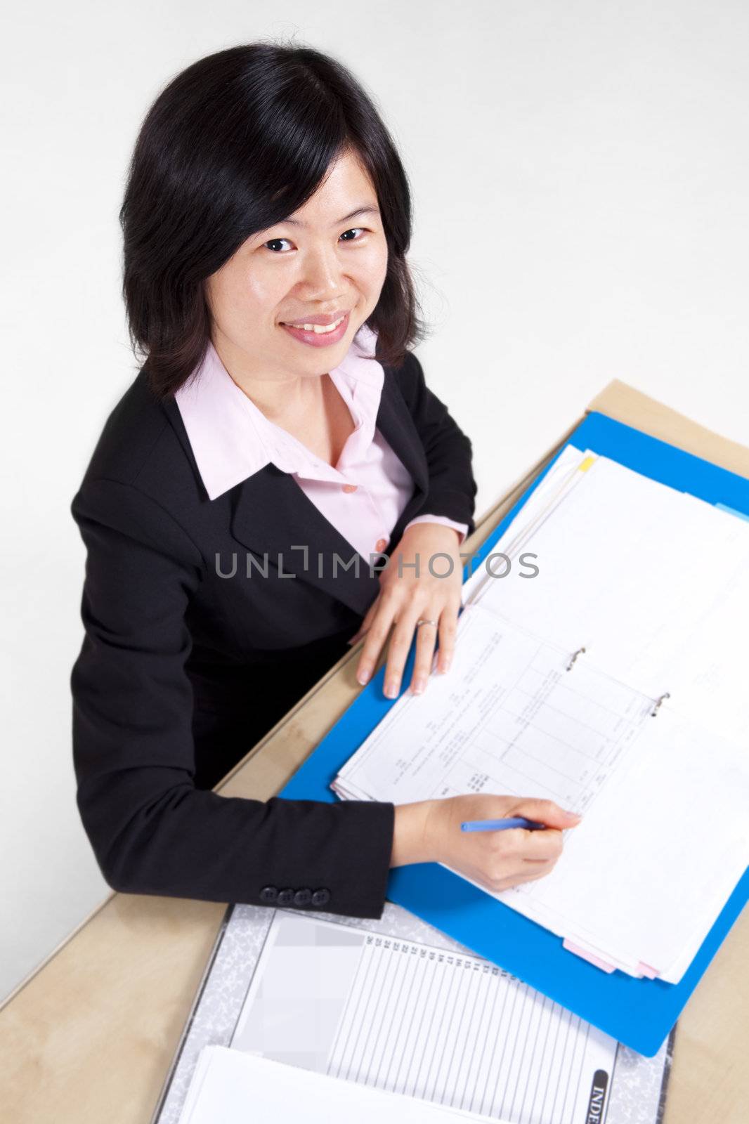 A businesswoman sitting at the table with document.