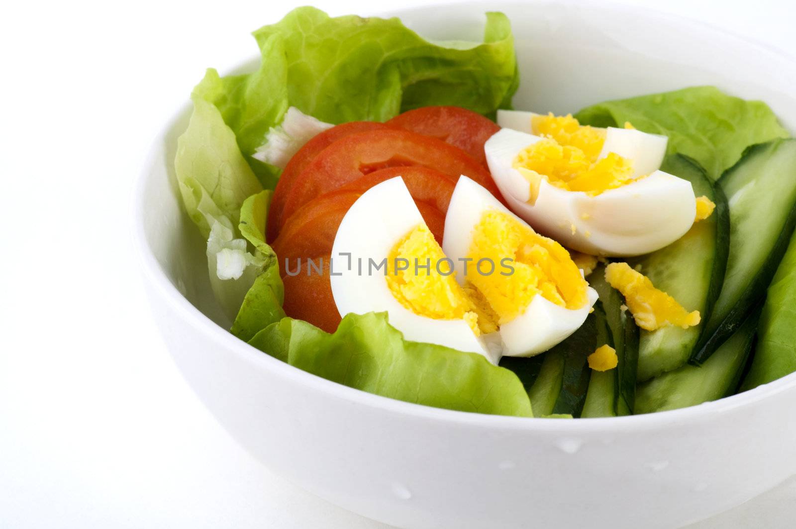 Bowl of fresh salad on white background