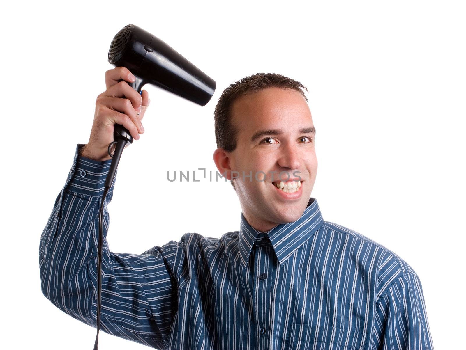 A smiling young man dressed for work and blowdrying his hair, isolated against a white background