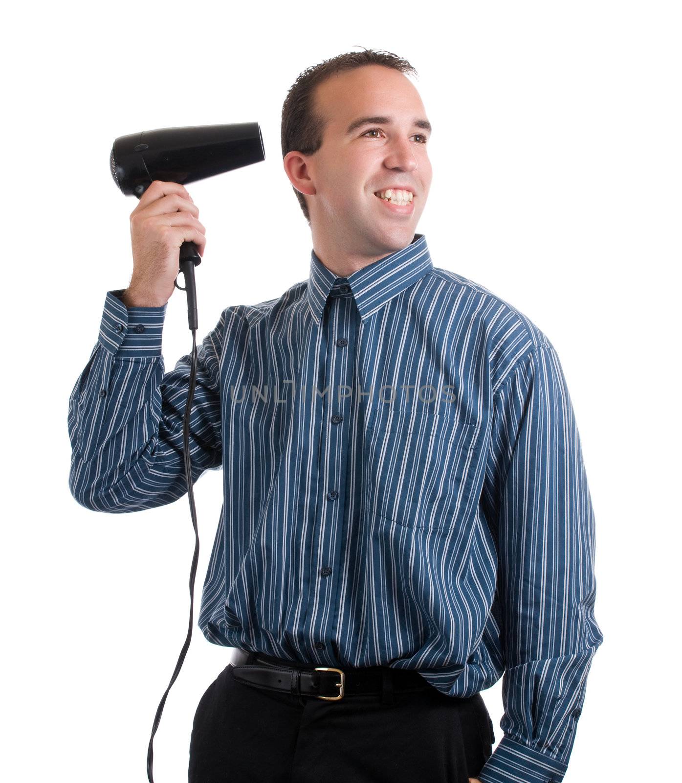 A smiling young man dressed for work and using a hot air dryer, isolated against a white background