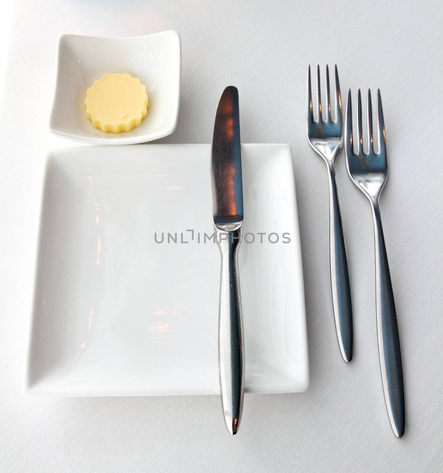 White empty plate with knife and fork