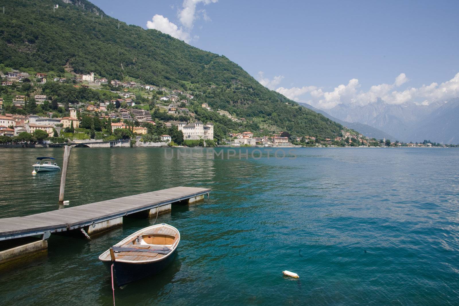 View of Gravedona, on the Lake Como, surrounded  by the Alps, at the North of Italy.Wooden boat and jetty on the front.