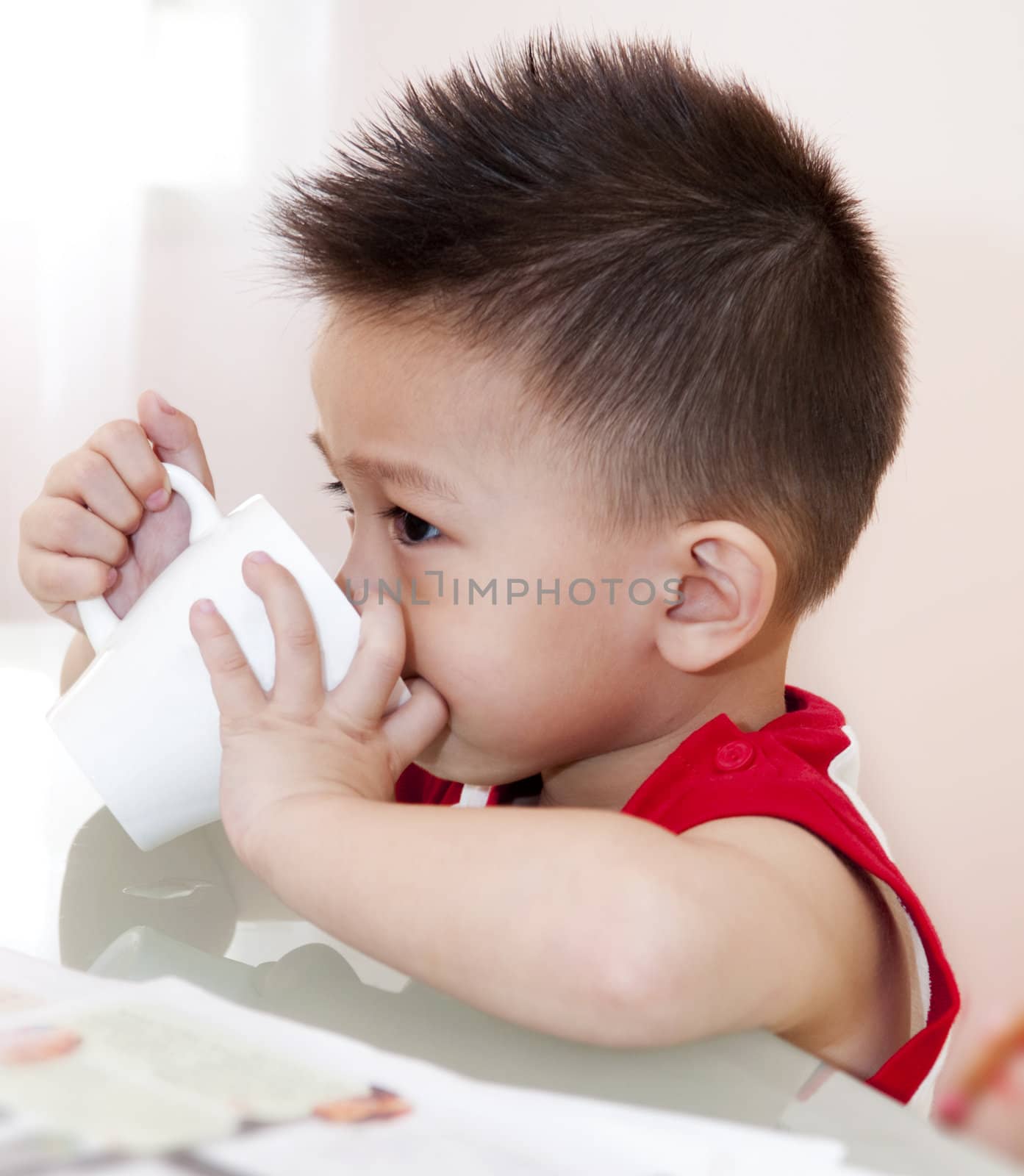 Young Asian Boy Takes a drink on breakfast.