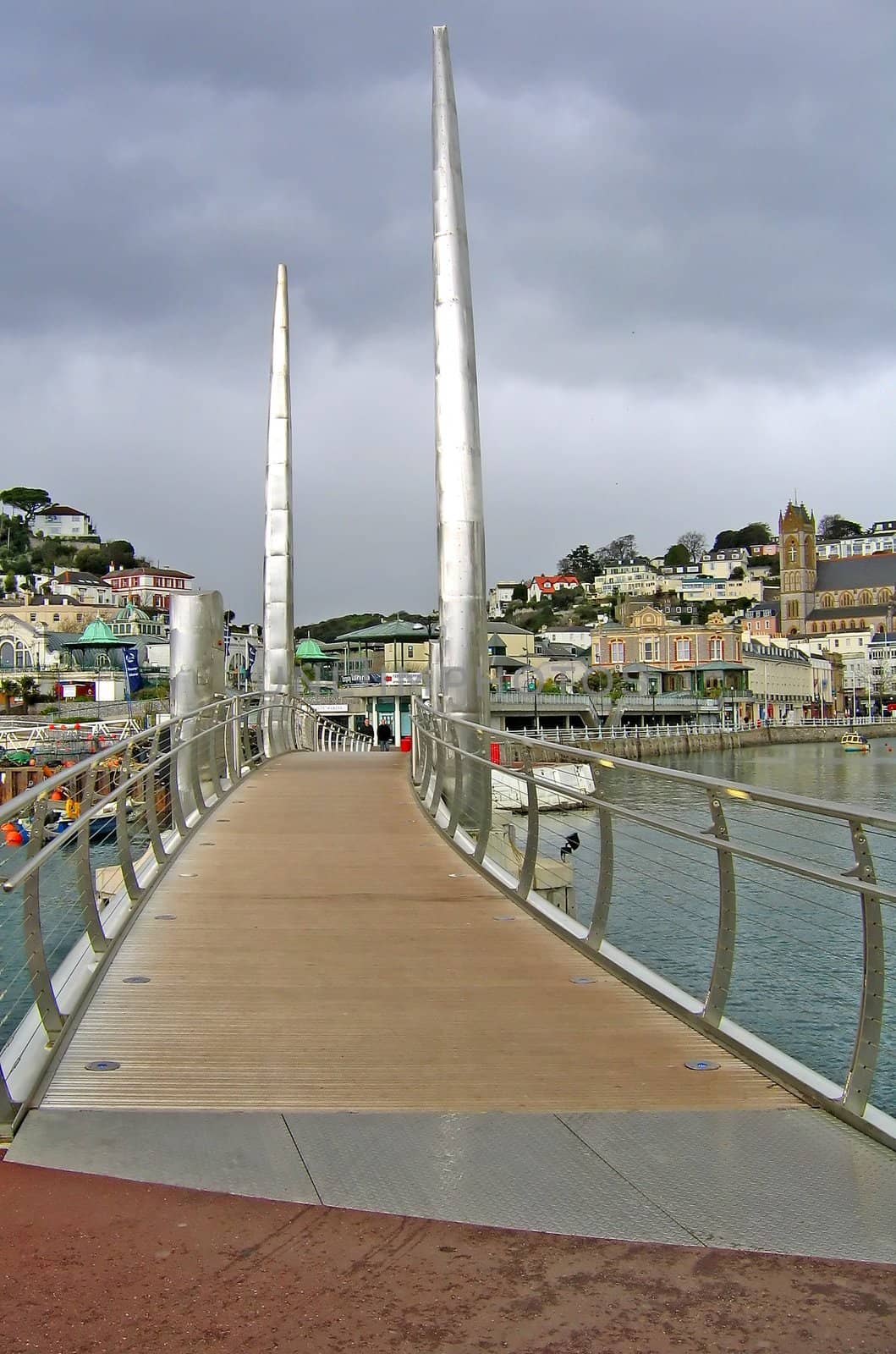 Walkway over pedestrial bridge in Plymouth, England with two shiney steel spires.