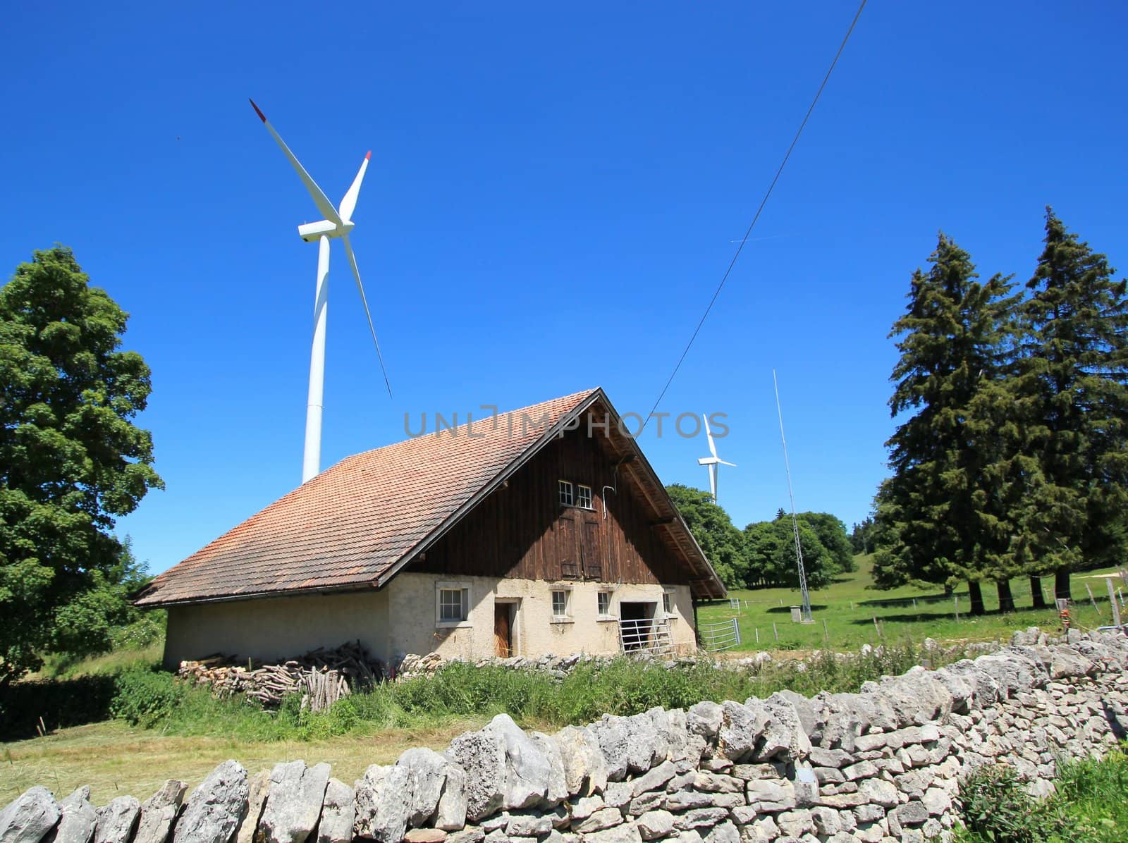 Small house made of wood and white wind turbines in the country by beautiful weather
