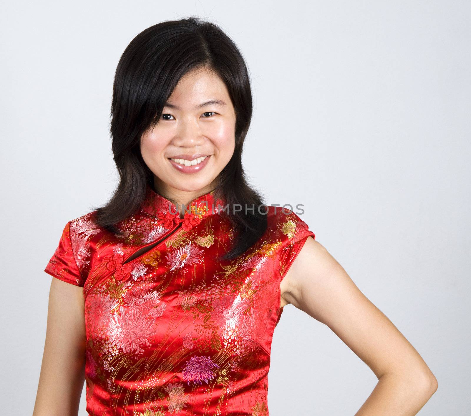 Oriental woman in red Cheongsam. Cheongsam also known in English as a mandarin gown, is  formal wear for important occasions. Red is lucky color of Chinese, red cheongsam usually wear by during new year day or wedding.