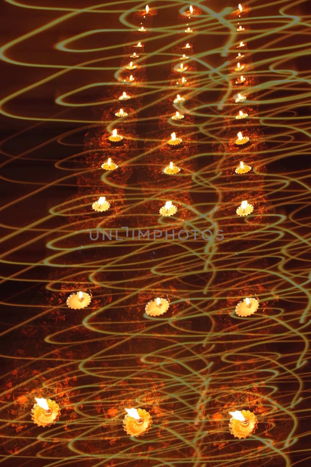 An abstract design of traditional Diwali lamps in light swirls for greetings.