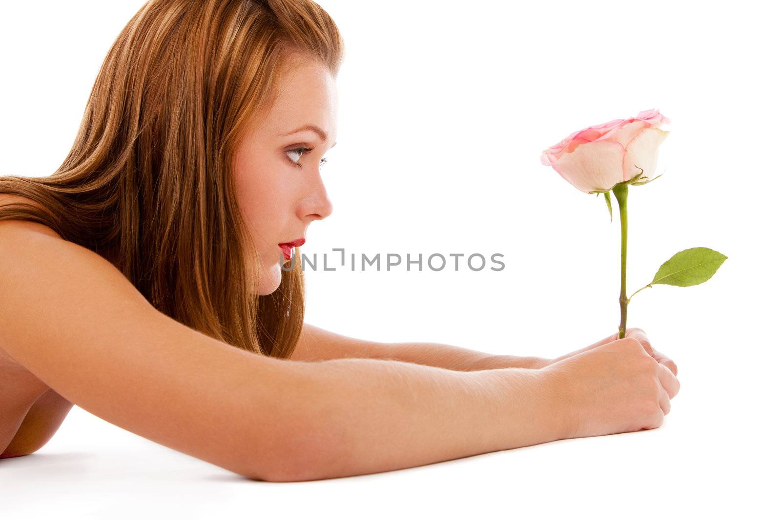 Nude girl looking at a beautiful rose