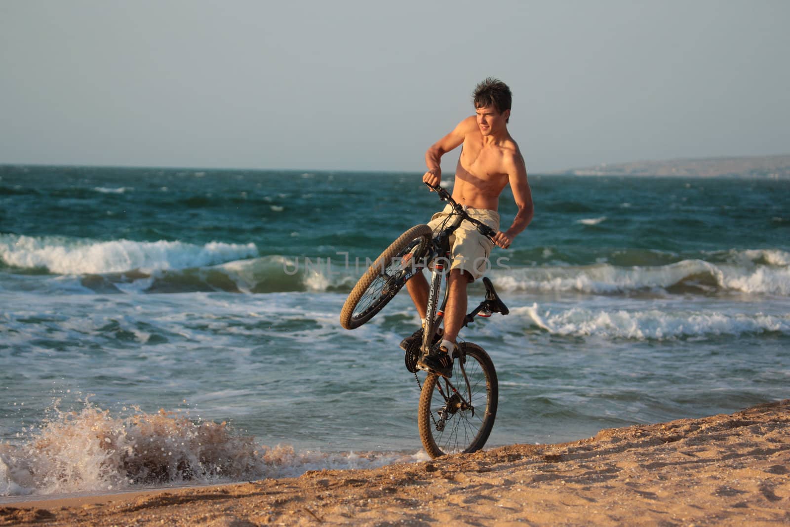 people series: young man cycle on the beach