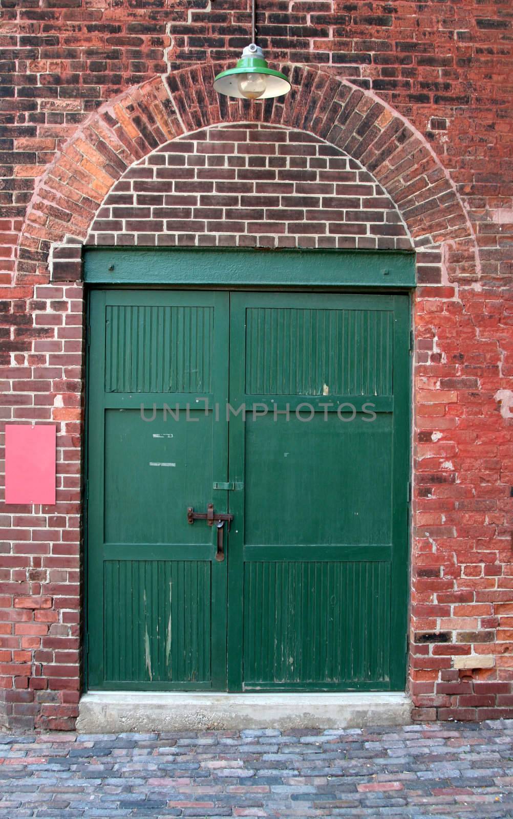 The green door of an old red brick warehouse.