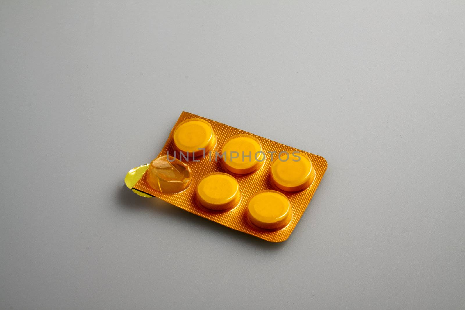 Great orange pills in a blister, over gary/white background