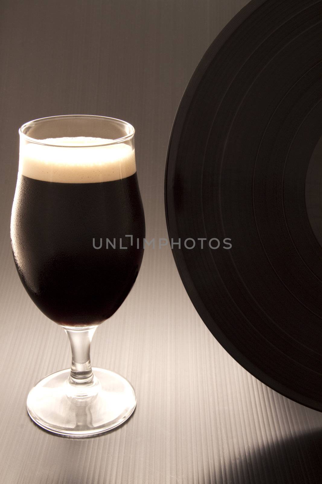 Close up of a glass of irish stout and a vinyl record