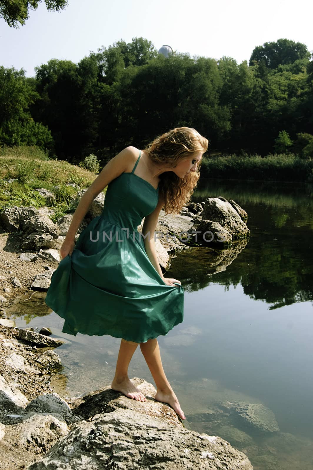 Sensual girl in elegant dress near lake