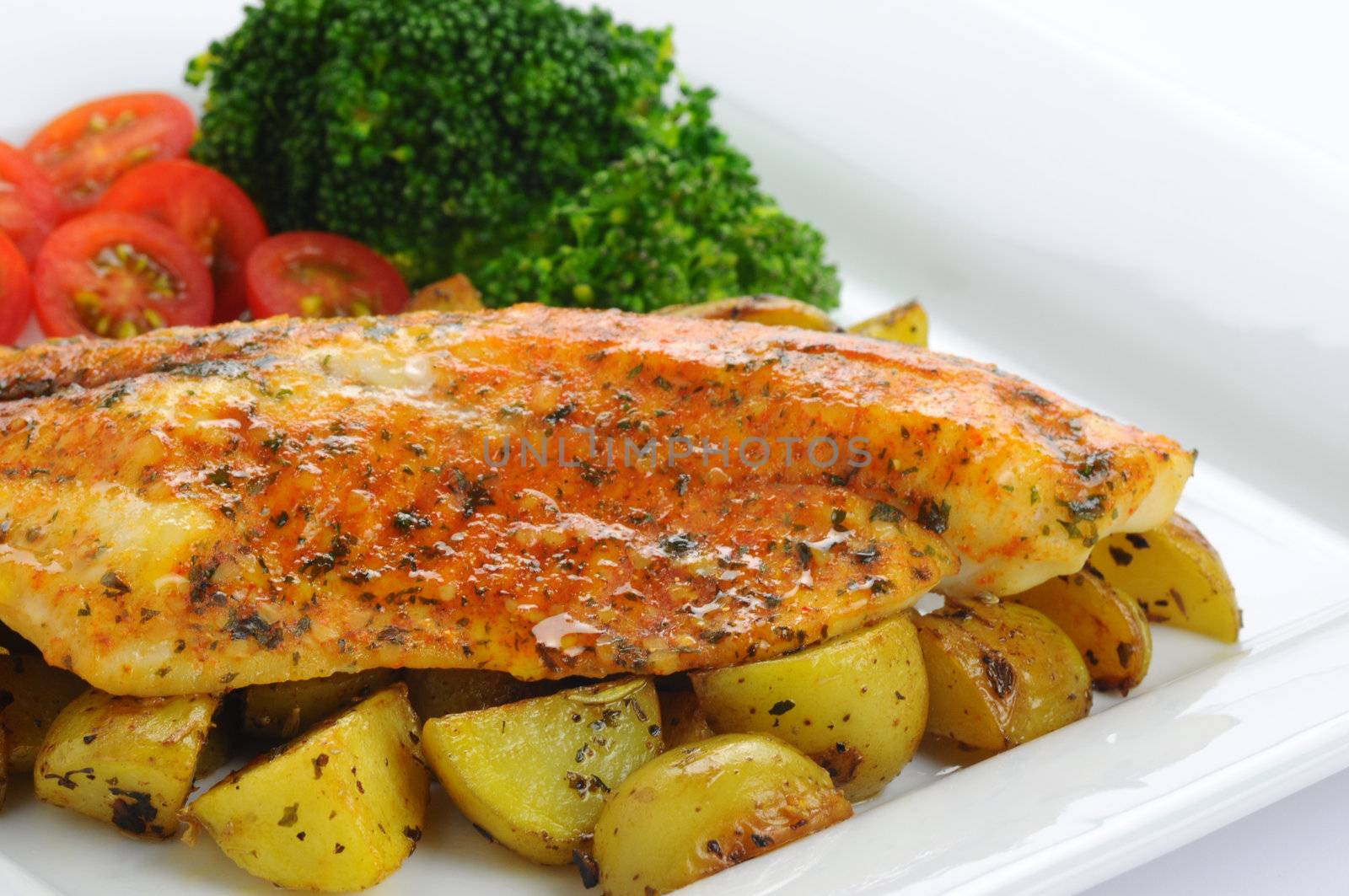 Delicious broiled tilapia served with fresh vegetables.