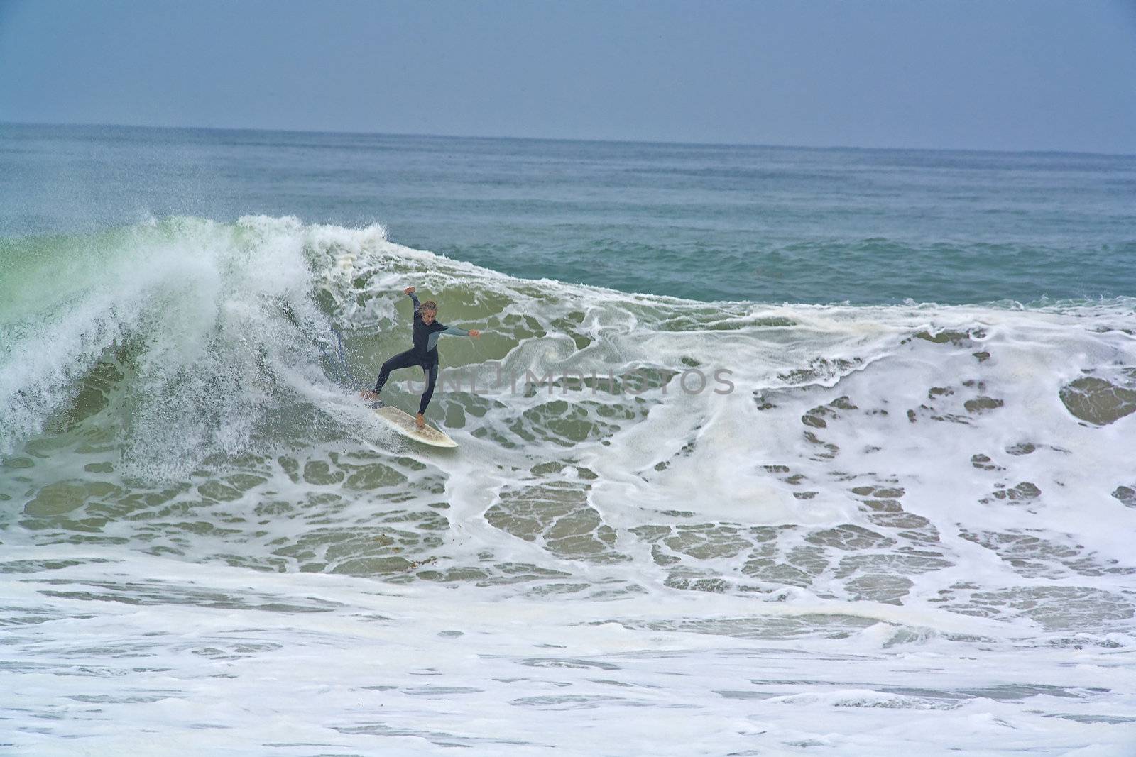 A Surfer drops into a Wave going Backside