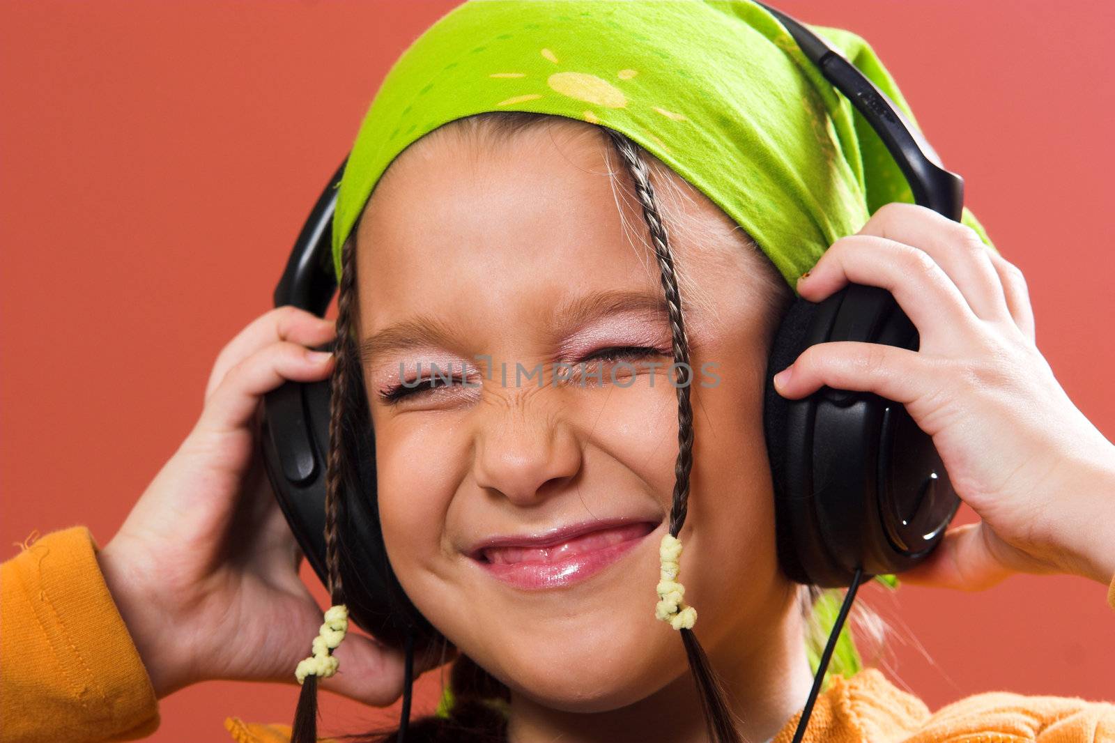 little pretty child listening music in headphones