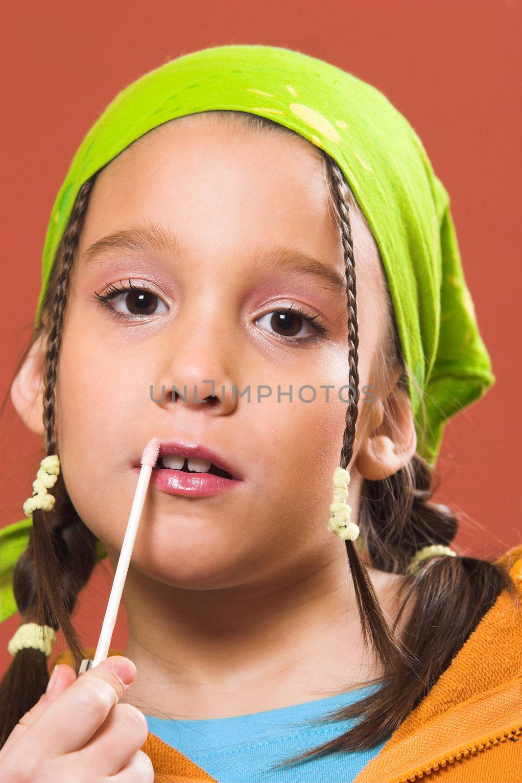 young pretty child applying make-up