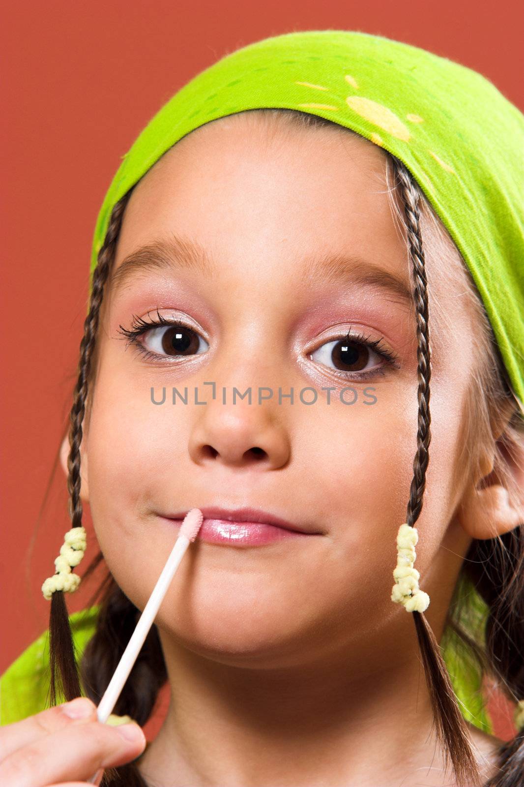 young pretty child applying make-up
