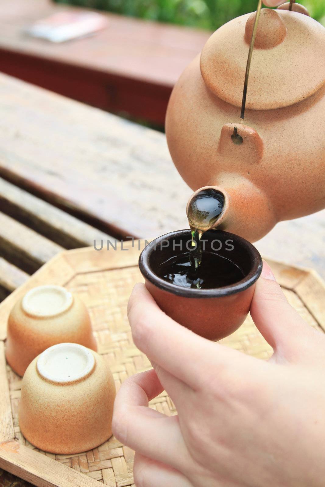 hand pouring chinese tea on the cup