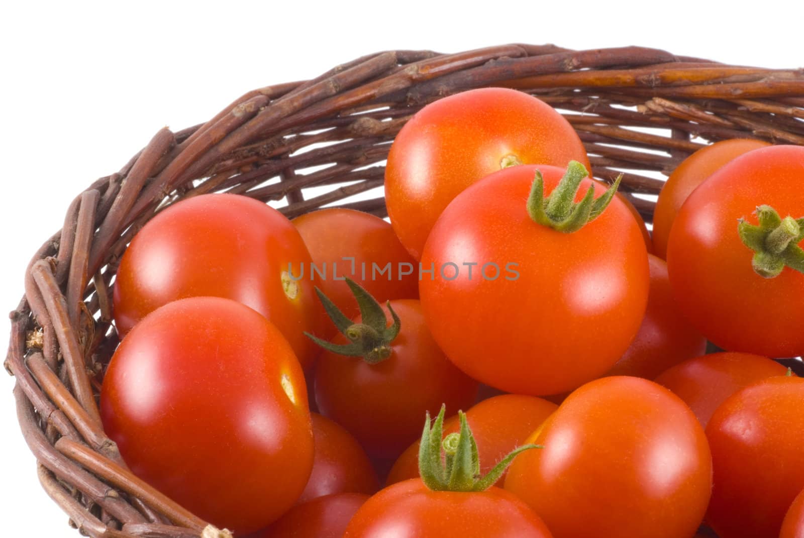 Macro photo of a basket full of beautiful ripe cherry tomatoes, isolated on white.