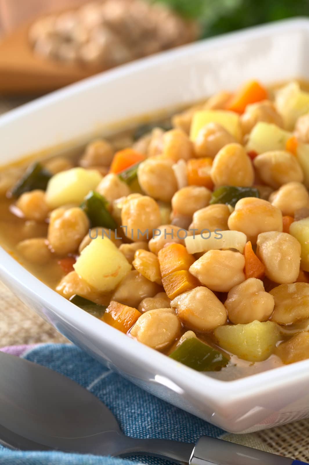 Vegetarian chickpea soup with carrots, potatoes, onions and leek (Selective Focus, Focus on the chickpeas in the front of the soup)