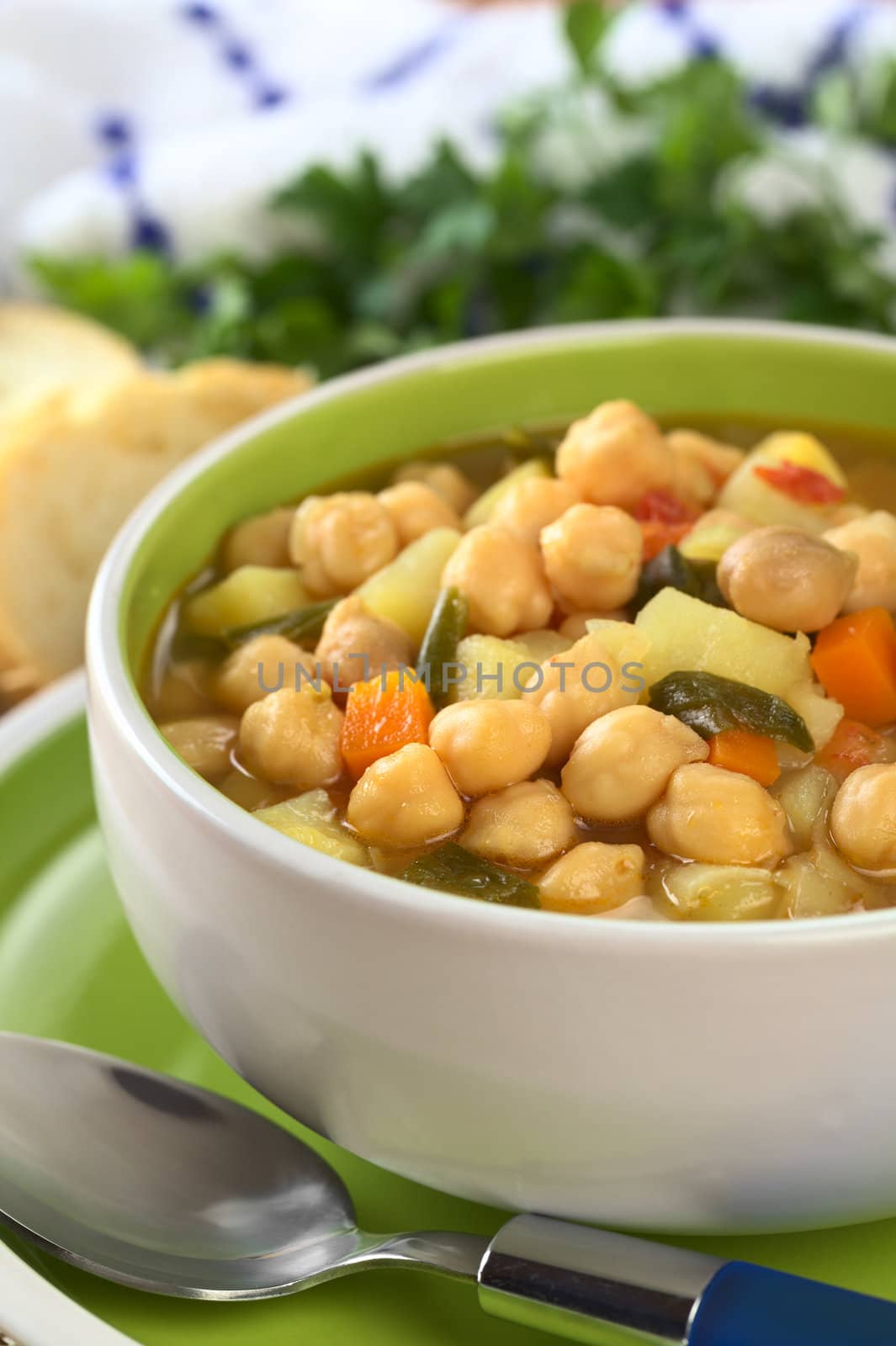 Vegetarian chickpea soup with carrots, potatoes, onions and leek (Selective Focus, Focus on the row of chickpeas in the front of the soup)