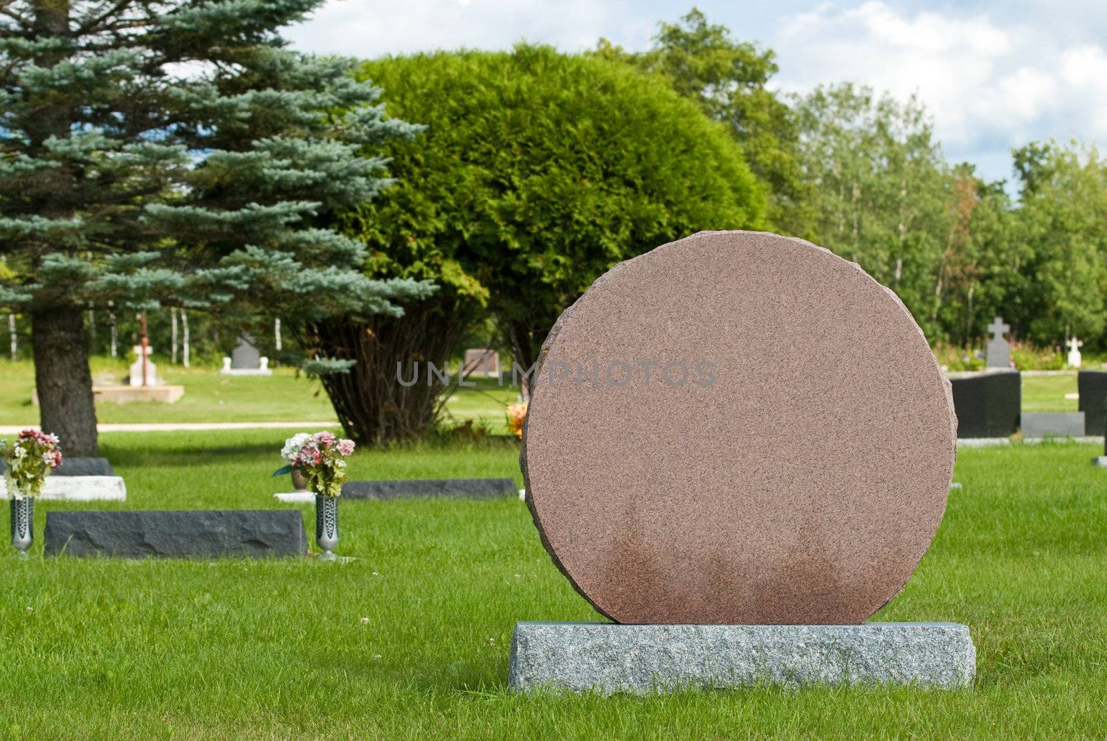 A blank headstone in a cemetery or graveyard allowing the designer to put what they want on it.