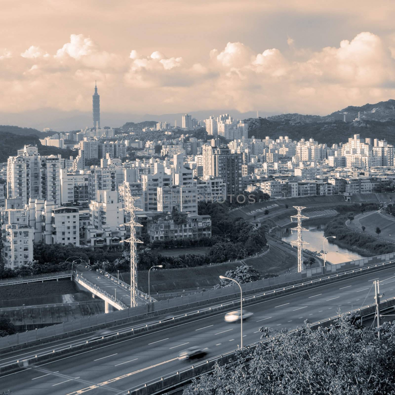 It is a cityscape photo of apartments and highway.