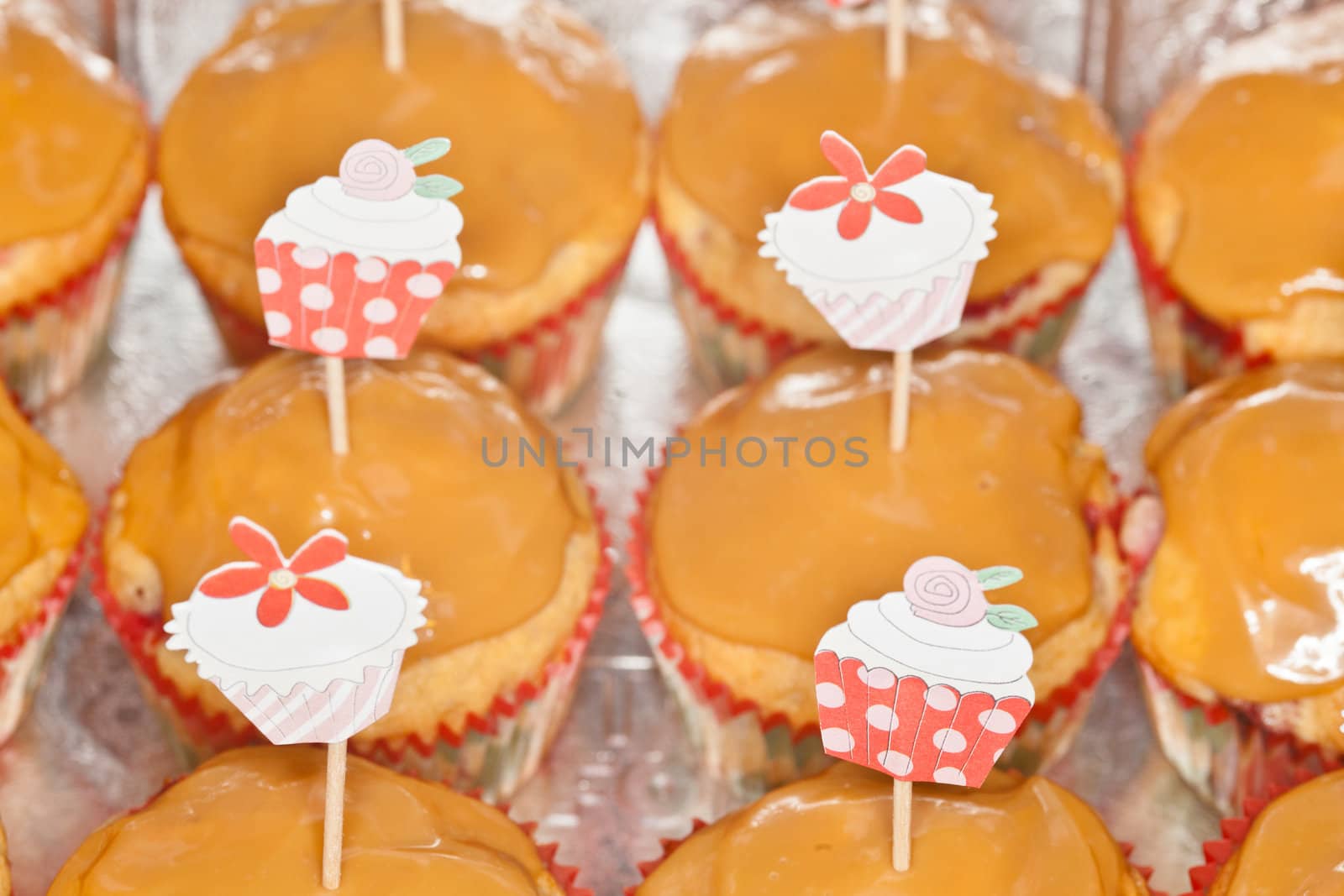 Tray of freshly baked homemade strawberry cupcakes with caramel topping