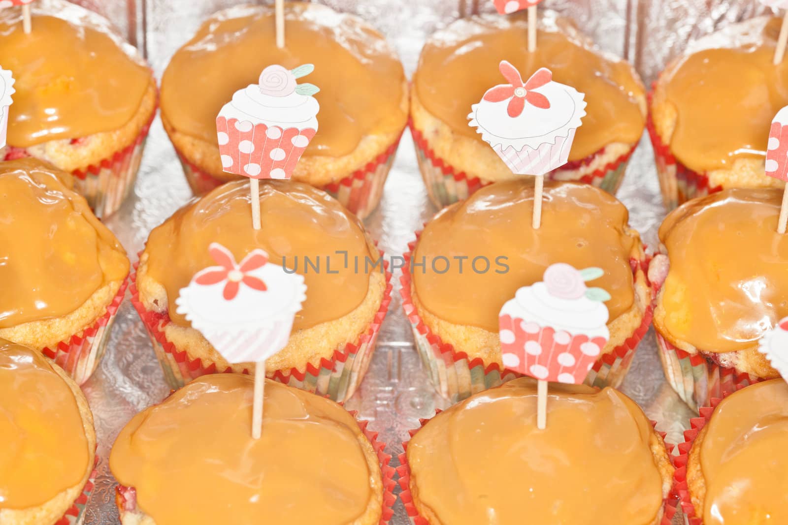 Tray of freshly baked homemade strawberry cupcakes with caramel topping