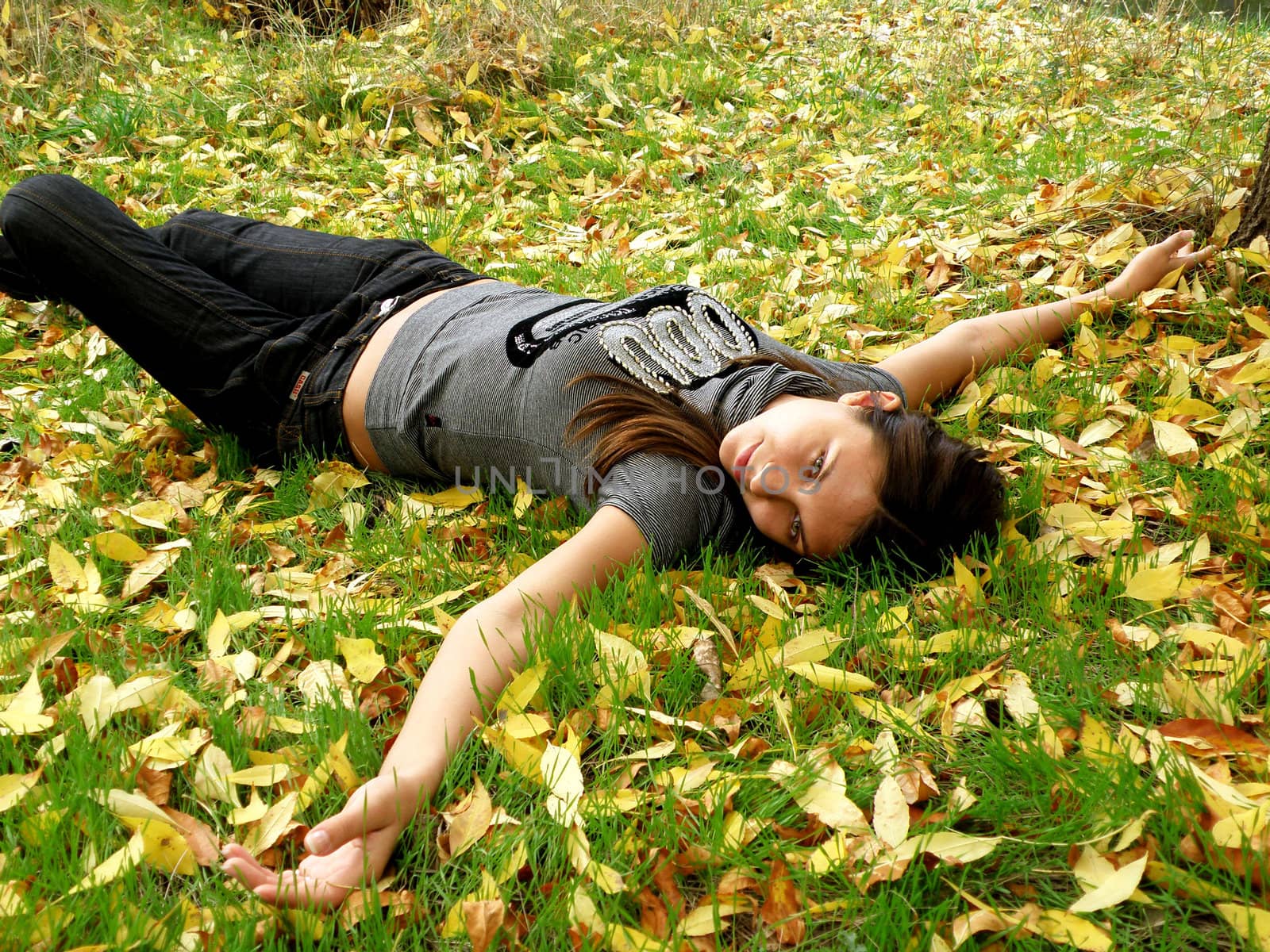 The young fine girl has a rest in warm autumn park  