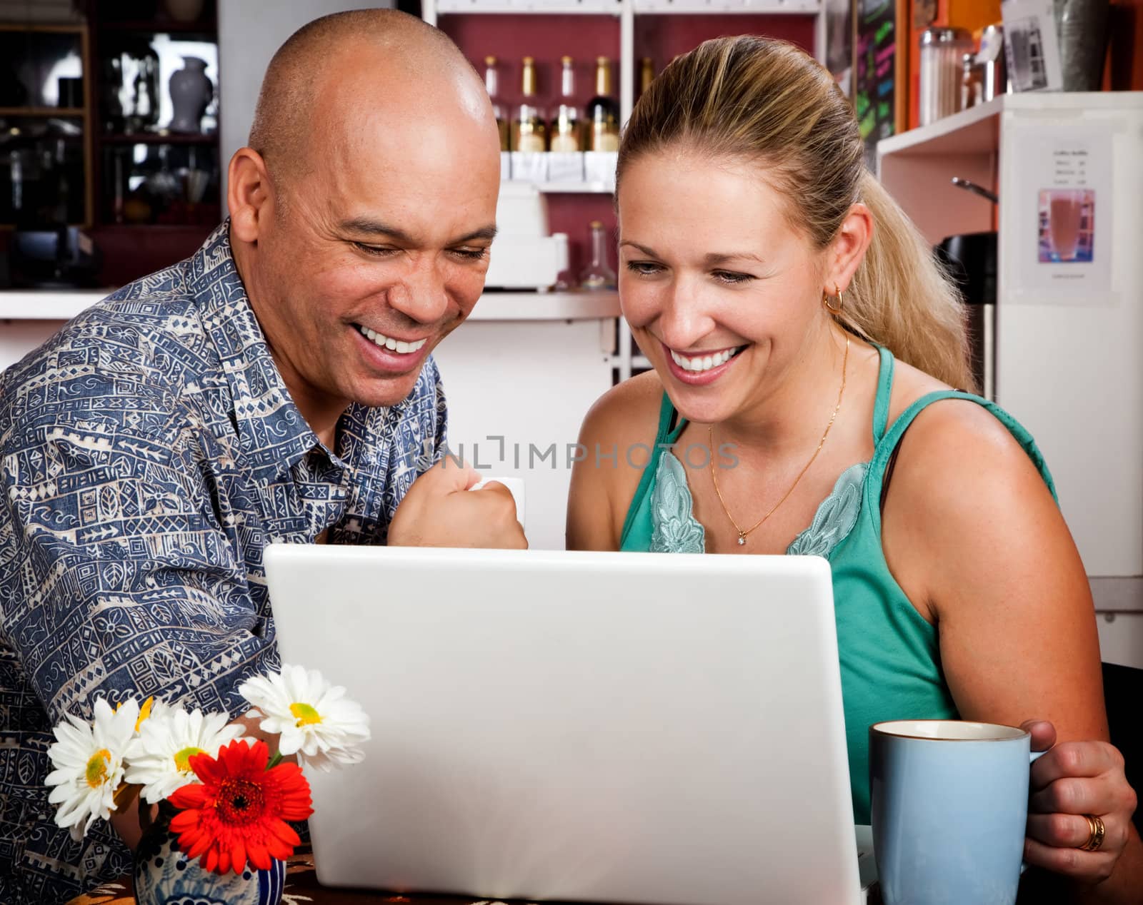 Adult couple in coffee house with laptop computer