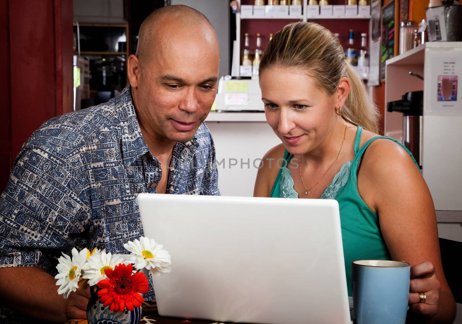 Couple in Coffee House with Laptop Computer by Creatista