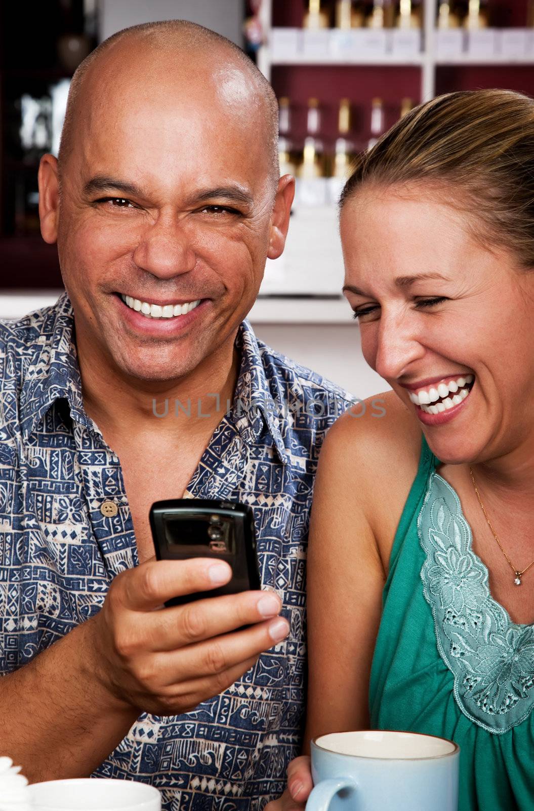 Attractive couple in a coffee house with cell phone