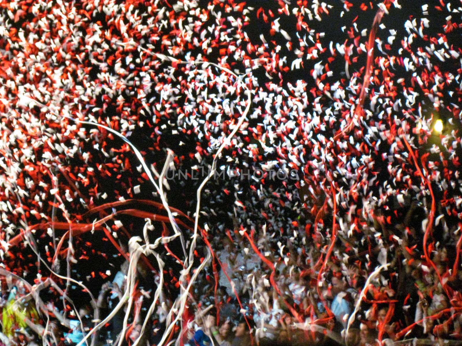 Red and White confetti and streamers against a dark sky.