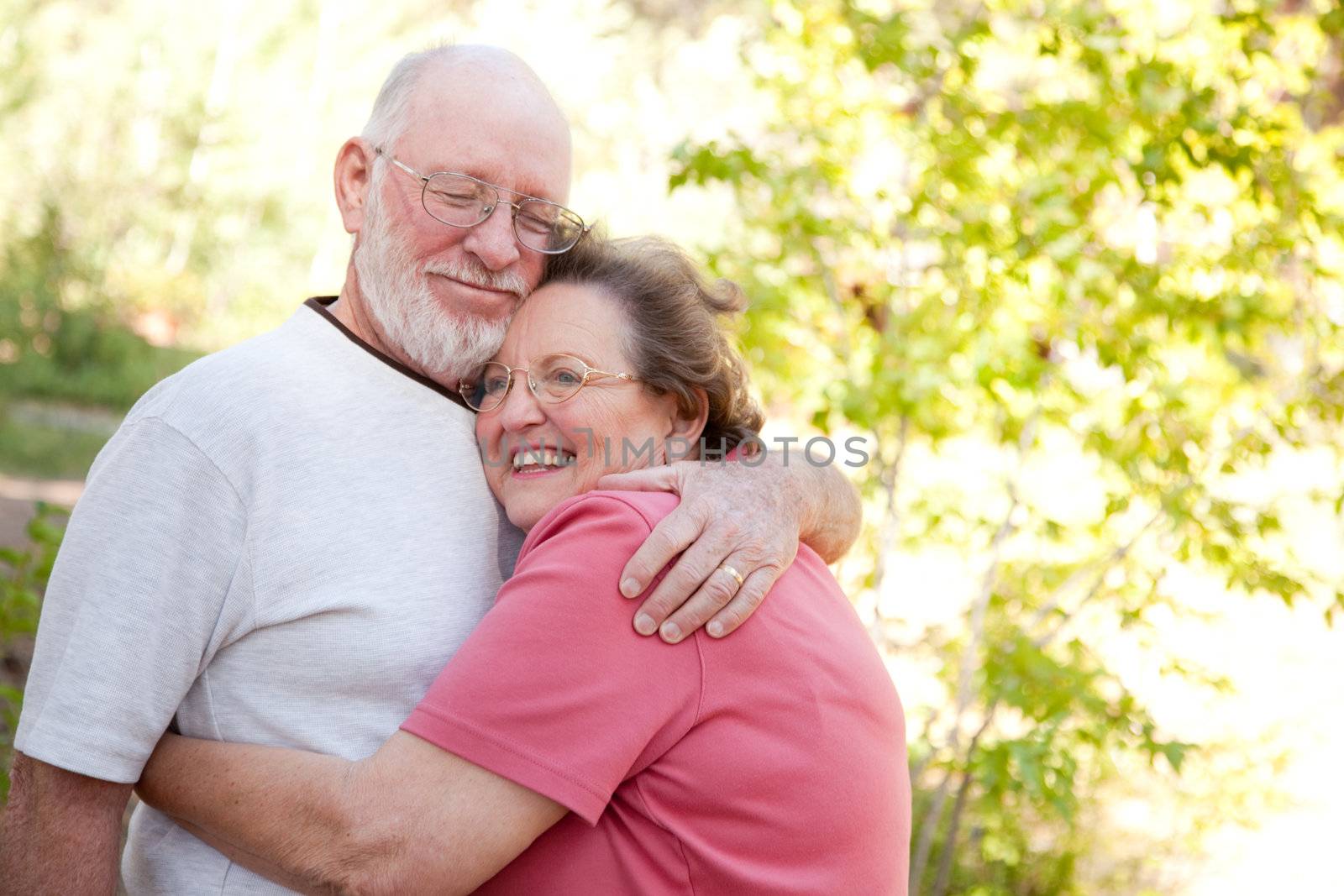 Loving Senior Couple Hugging Enjoying the Outdoors Together.