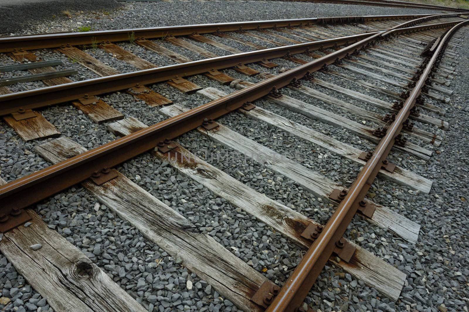 Rusty railway tracks stretch away into the distance, converging.