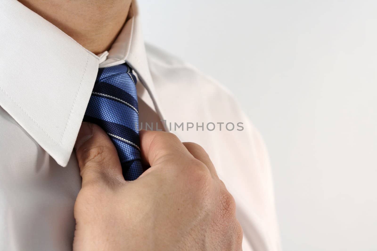 Business man tying a tie