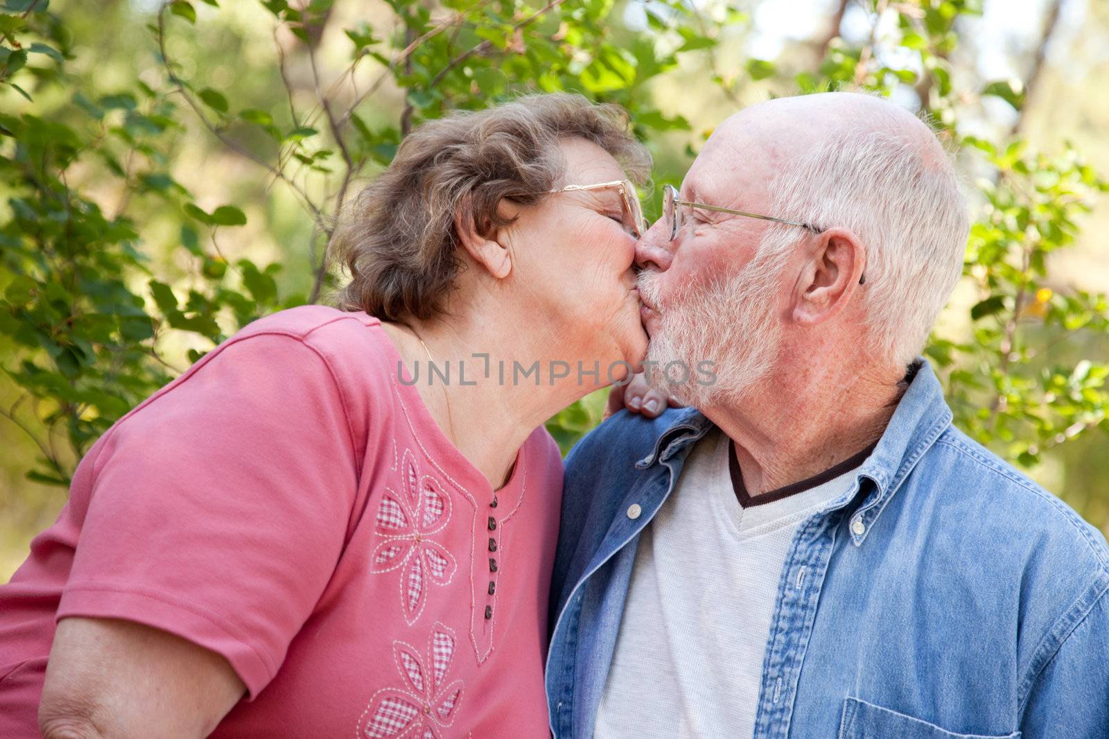 Loving Senior Couple Kissing Enjoying the Outdoors Together.