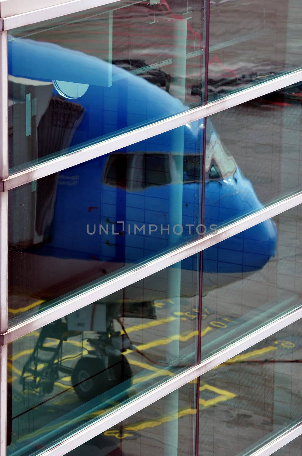 Air transportation: passenger airliner reflection on terminal windows.