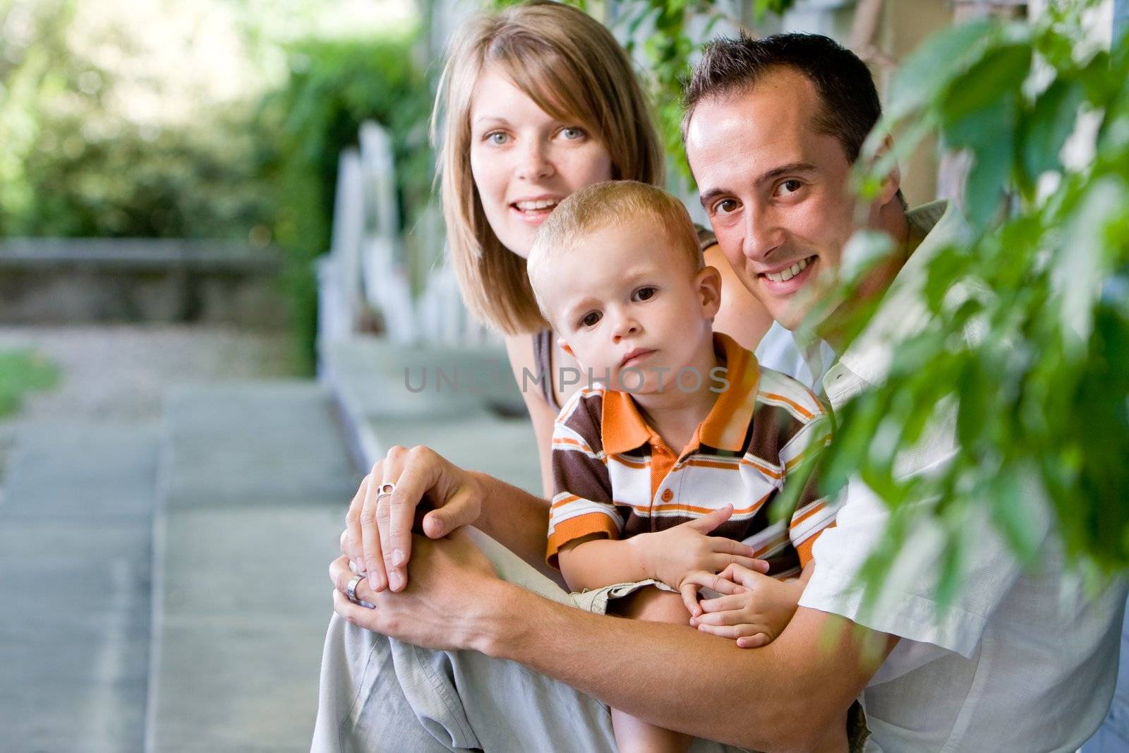 Happy perfect young family with dad, mom and son outdoors having fun