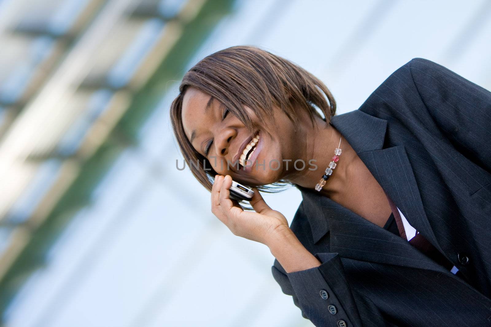 African american business woman talking on a mobile cell phone in front of an office building