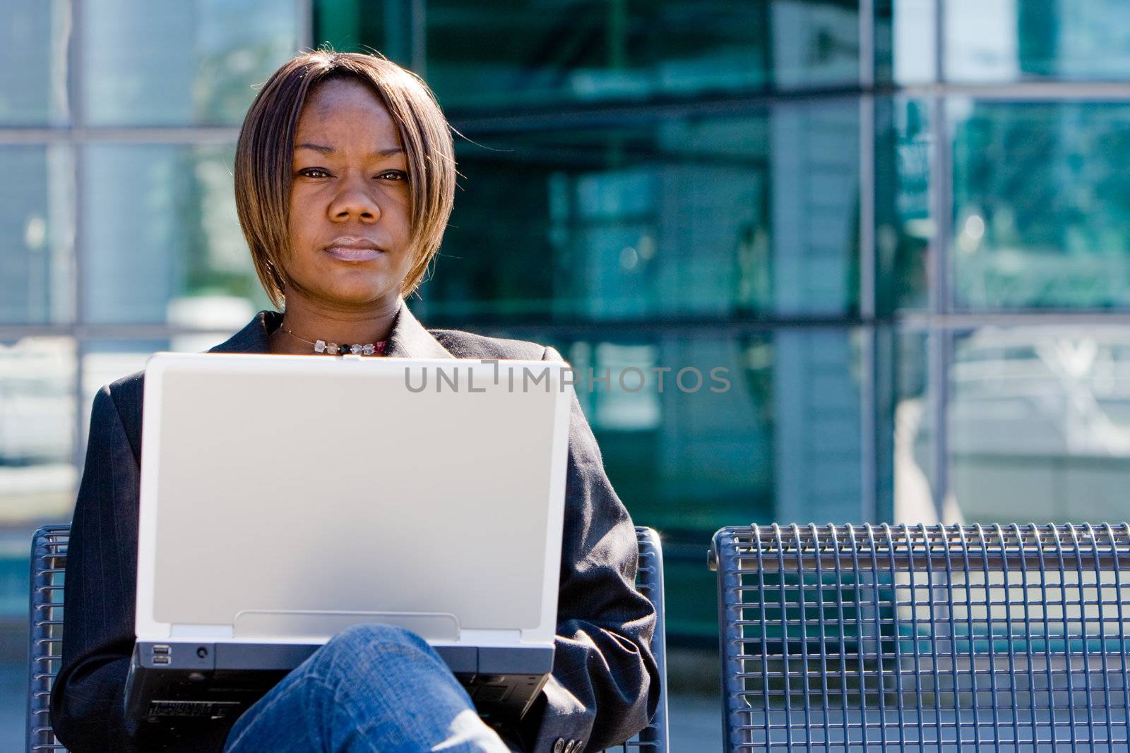 African american business woman with a computer notebook browsing outside an office building